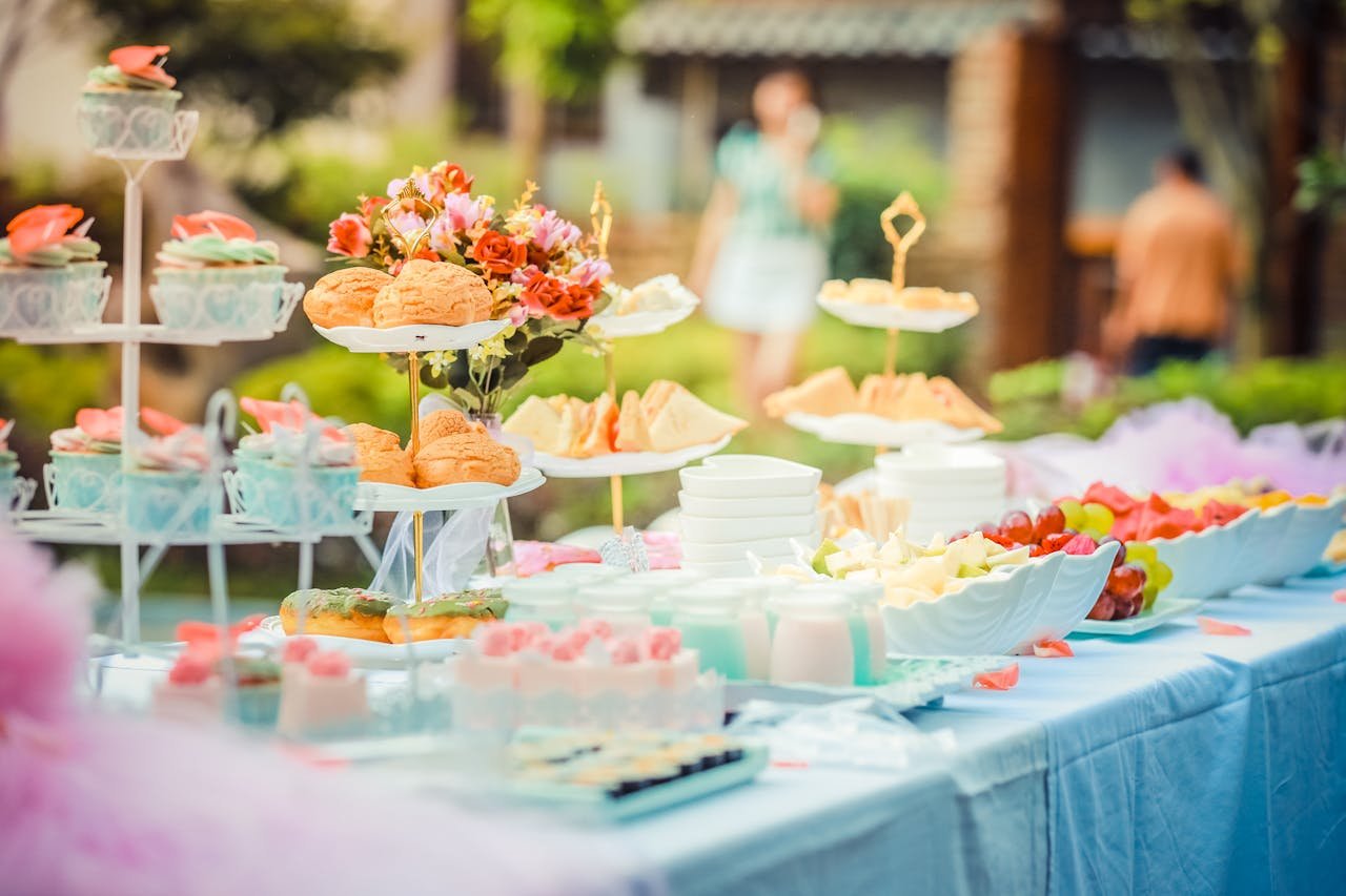 services-04 A vibrant outdoor buffet table showcasing an array of colorful pastries and fruits, perfect for parties.